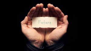 A man holding a card in cupped hands with a hand written message on it, Future.